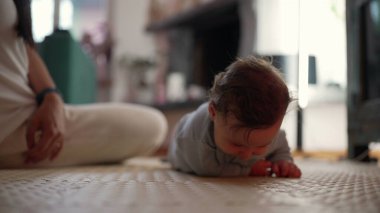 Bebek paspasın üzerinde yuvarlanıyor, motor becerilerini geliştiriyor, erken fiziksel gelişim, vücut koordinasyonunu öğreniyor, bebek hareketlerinde dönüm noktası, huzur dolu bir ev.