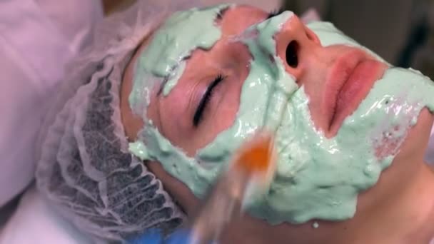 Cosmetologia médico fazendo máscara cosmética no rosto — Vídeo de Stock