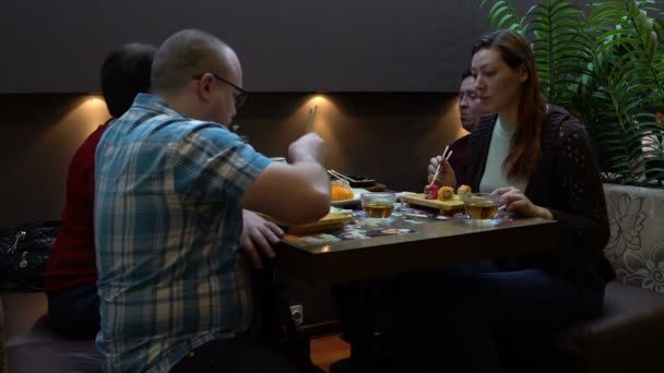 Четыре человека едят суши японский ресторан — стоковое видео