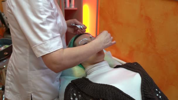 Косметолог мазає кремом на бровах — стокове відео