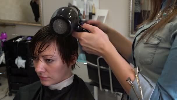Парикмахер сушит волосы фен — стоковое видео