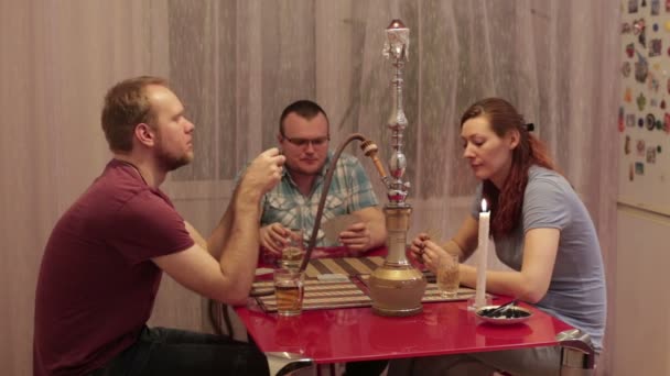 Hombres y mujeres fumando shisha y jugando a las cartas — Vídeo de stock