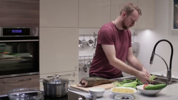 O homem na cozinha lava alface — Vídeo de Stock