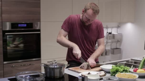 Чоловік розрізав рибу на стейки — стокове відео