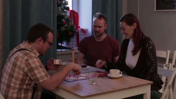 Familie spelen een bordspel in een café — Stockvideo