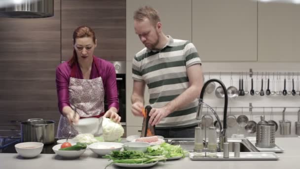 Young couple in the kitchen preparing dinner — Stock Video
