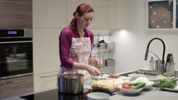 Mulher na cozinha coloca tomates picados na forma — Vídeo de Stock