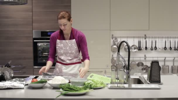 Woman puts a dish in the oven for baking — Stockvideo