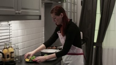 Kadın bir balık biftek bir tabağına koyuyor.