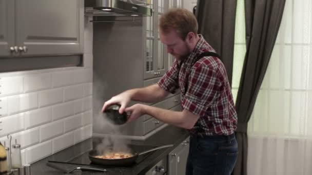 O homem frita o camarão em uma frigideira — Vídeo de Stock