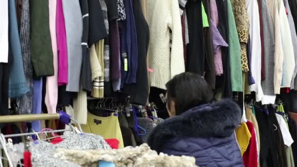 Menina escolhe roupas e coloca-lo no carrinho — Vídeo de Stock