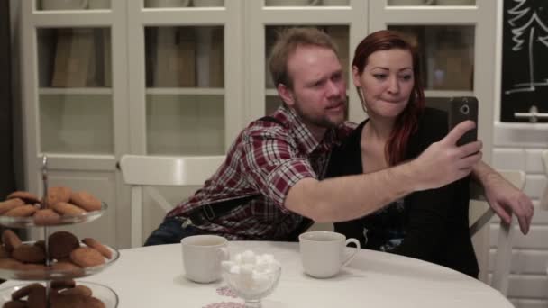 Woman and man sitting at the table doing selfie — Stock Video