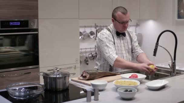 El hombre en la cocina lava verduras — Vídeo de stock