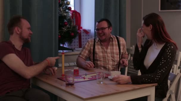 Tres personas juegan un juego de mesa en un café — Vídeo de stock