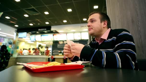 Mannen i Fastfood äta pommes frites — Stockvideo