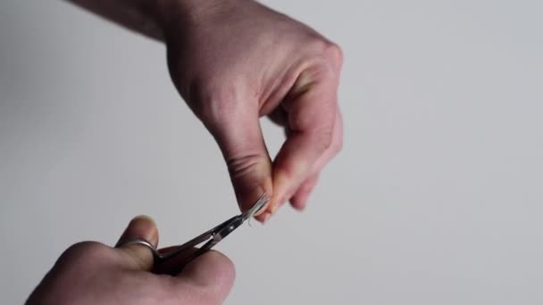 El hombre recorta las uñas en su mano izquierda — Vídeos de Stock