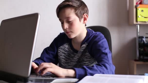 Chico escribiendo en el teclado del ordenador portátil — Vídeo de stock