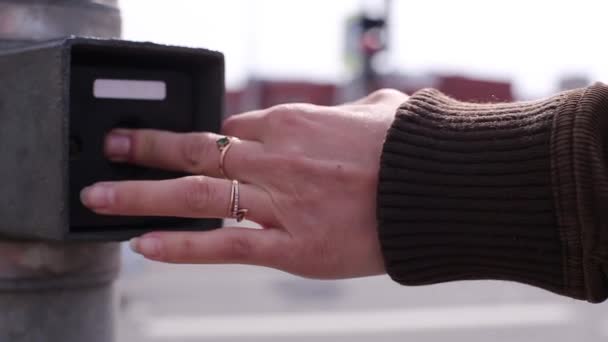 Eine Frau drückt einen Knopf, der den Verkehr umschaltet — Stockvideo