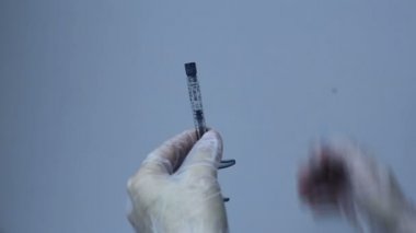 Doktor elinde iğne şırıngayı koymak.