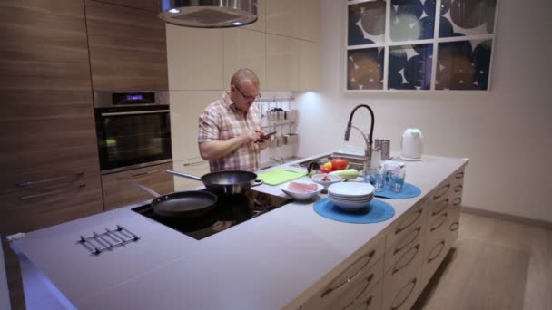 Hombre en la cocina usando Smartphone — Vídeos de Stock