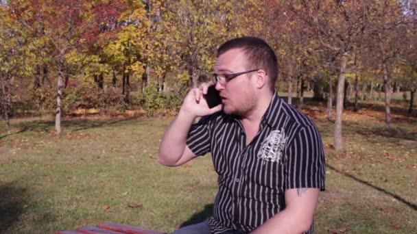 Man talar via telefon i höst Park — Stockvideo