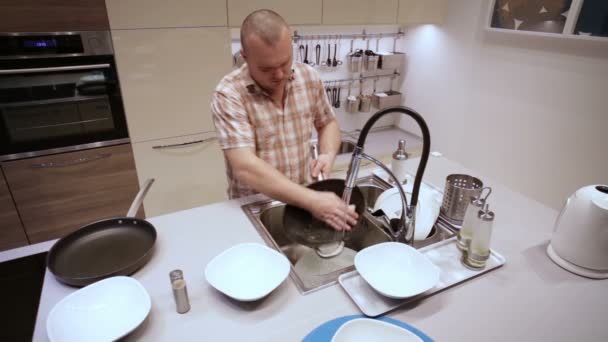 Az ember mossa egy serpenyőben, a mosogató — Stock videók