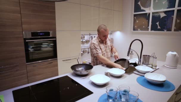 Homem lava as panelas no dissipador — Vídeo de Stock