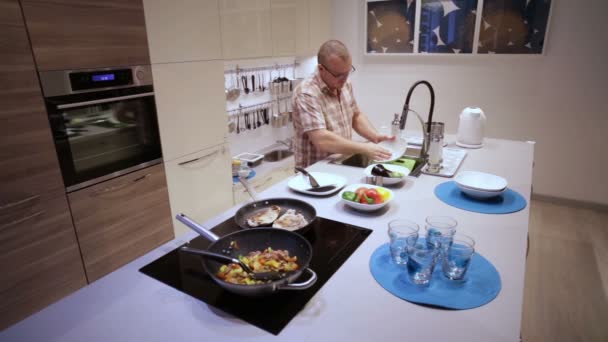 Чоловік миє брудні посуду — стокове відео