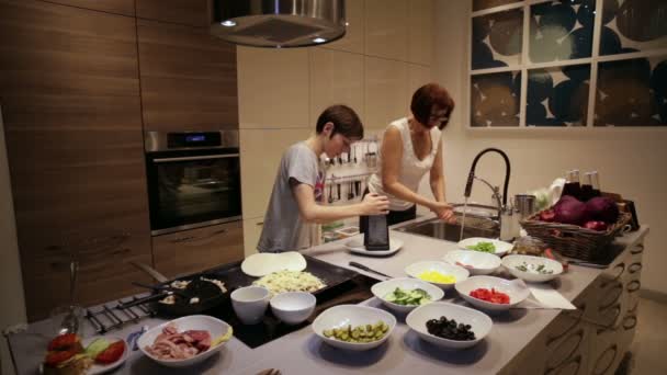 Moeder en zoon zijn voorbereiding in de keuken — Stockvideo
