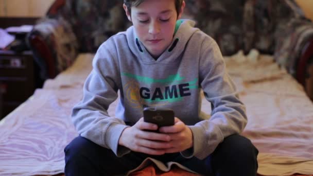 Adolescent garçon jouer dans jeu sur smartphone — Video