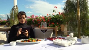 Kadın bir akıllı telefon güzel restoranda sahiptir