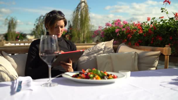 Mujer con una tableta en el restaurante — Vídeos de Stock