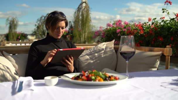 Młoda kobieta z tabletem w pięknej restauracji — Wideo stockowe