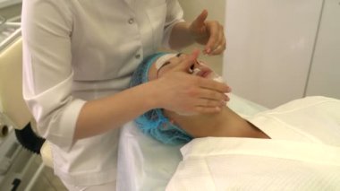 Güzellik uzmanı kozmetik maskesi yüzünde koymak.