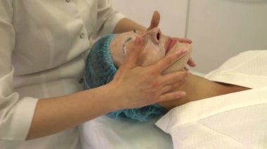 Güzellik uzmanı bir yüz kremi yüz masaj yapar