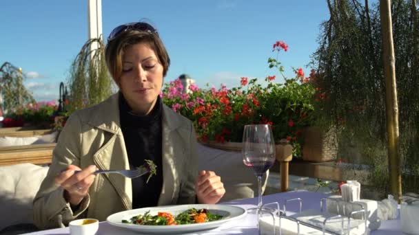 Γυναίκα τρώει μια σαλάτα στην βεράντα του εστιατορίου — Αρχείο Βίντεο