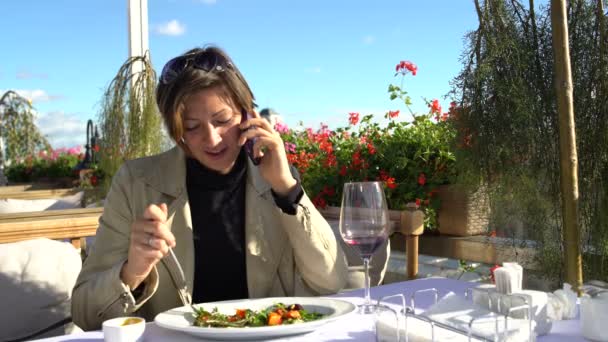 Γυναίκα που μιλάτε στο τηλέφωνο στο εστιατόριο στη βεράντα — Αρχείο Βίντεο