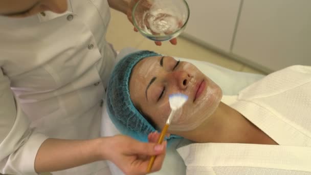 Kosmetikerin cremt Gesicht mit Bürsten ein — Stockvideo