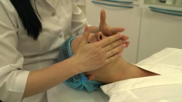 Crema cosmetologa per il viso e massaggi viso donna — Video Stock