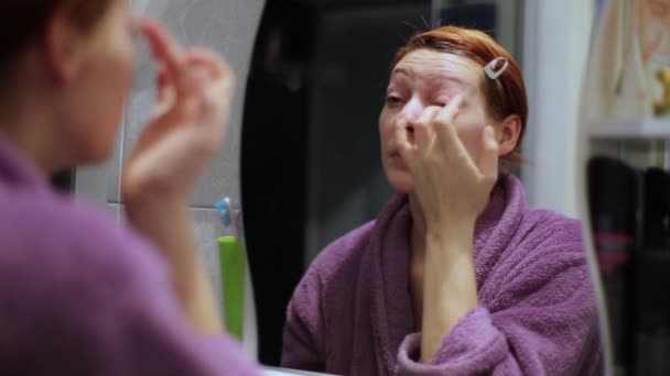 Femme obtient crème pour les yeux un miroir — Video