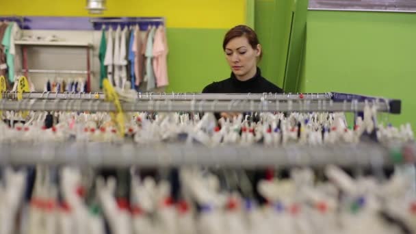 Vrouw op zoek naar kleding In de winkel — Stockvideo