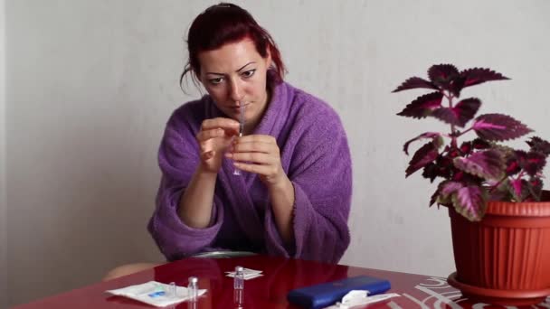 Женщина готовит шприц к инъекции — стоковое видео