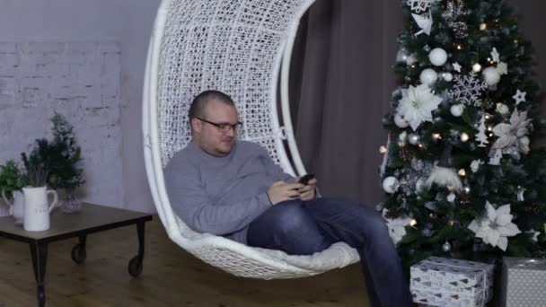 Hombre usando un teléfono inteligente, fondo de Navidad — Vídeo de stock