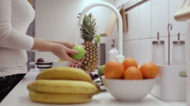 Kız bir yeşil elma mutfak lavaboda yıkar