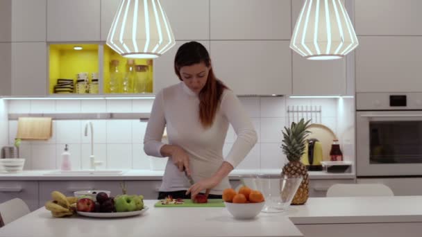 Дівчина ріже Apple на борту з ножем — стокове відео