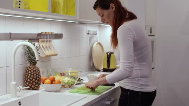 Zwangere vrouw snijden druif in de keuken — Stockvideo