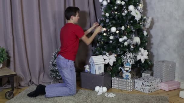 De kleding van de jongen omhoog kerstboom — Stockvideo