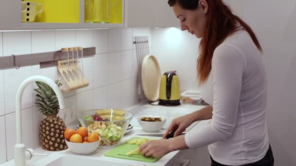Kvinnan skär ananas med en kniv i styrelsen — Stockvideo