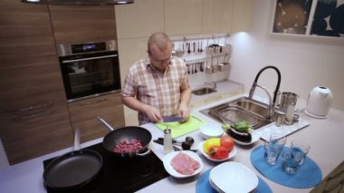 Adam tahtada sosis keser ve tavada yatıyordu