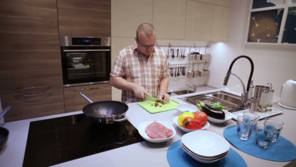 Man snijdt de worstjes op het bord en lag in de pan — Stockvideo